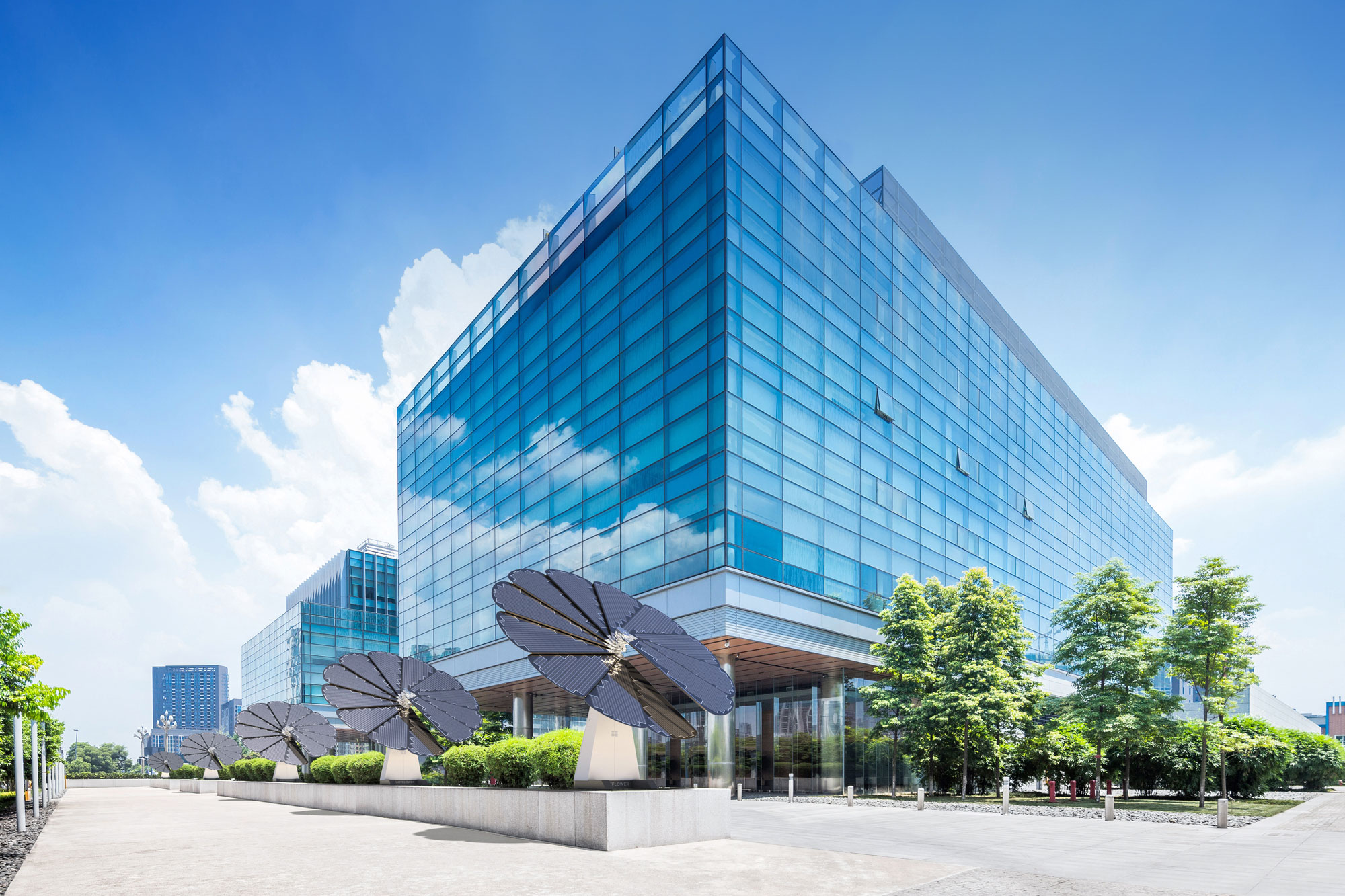 5 SmartFlower Solar Panels Line a City Street Next to a Glass Business Building