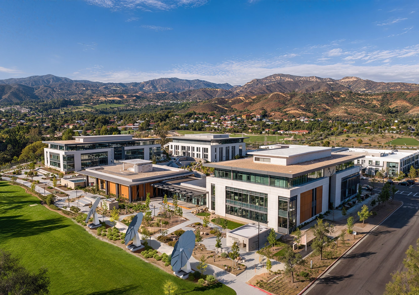 Sustainable university buildings with multiple SmartFlower solar units and manicured green lawns