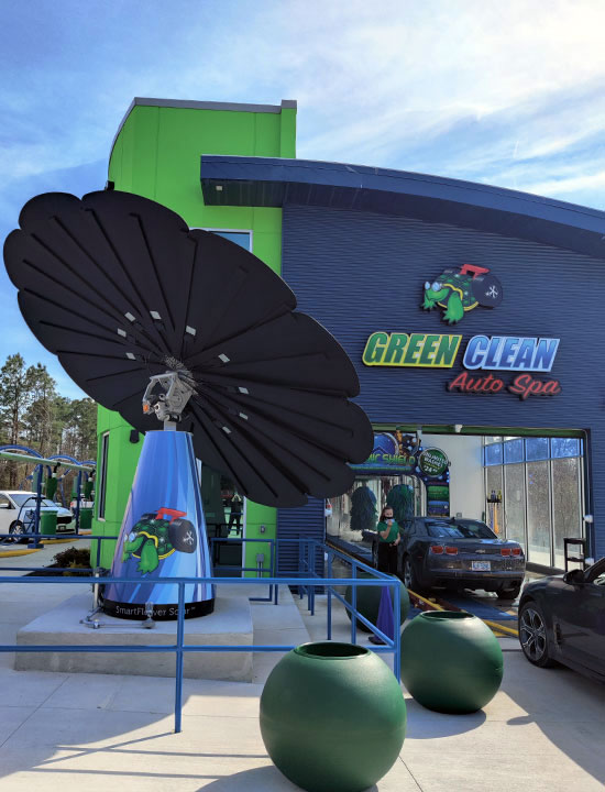 Solar panels installed at green-themed auto spa entrance beside car vacuum stations and vivid building