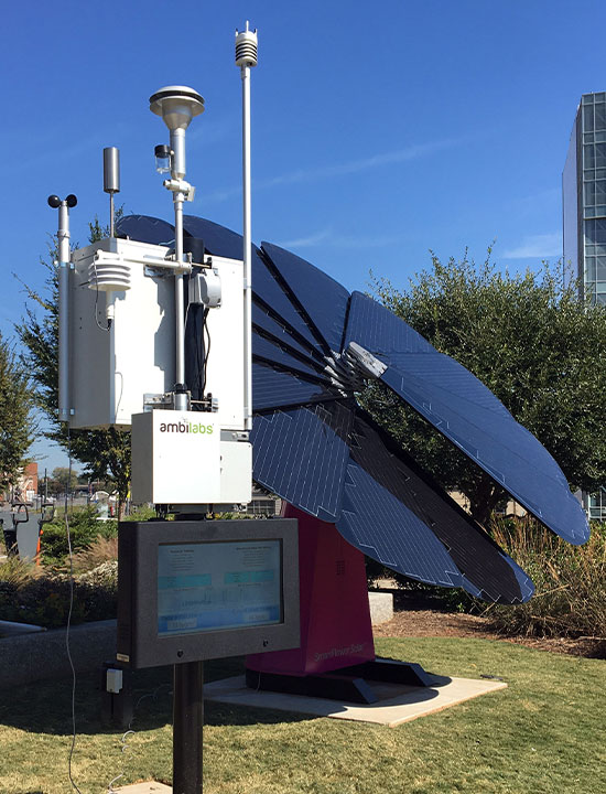 Renewable SmartFlower energy unit alongside climate sensors in eco-friendly public landscape