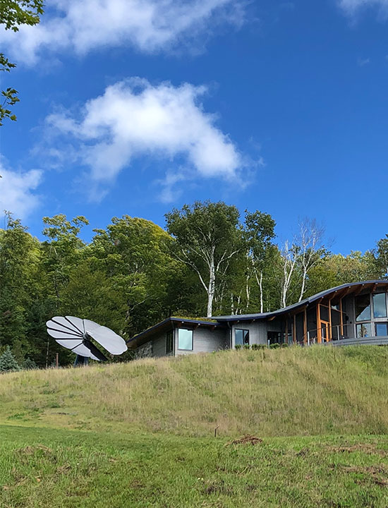 Sustainable home nestled in greenery with SmartFlower solar system capturing sunlight for renewable energy