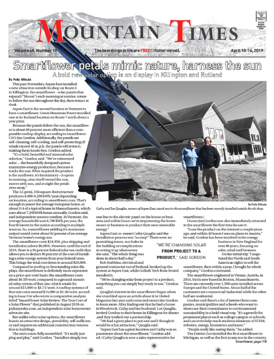 Newspaper article featuring Smartflower solar panel installation in Vermont with couple standing beside it