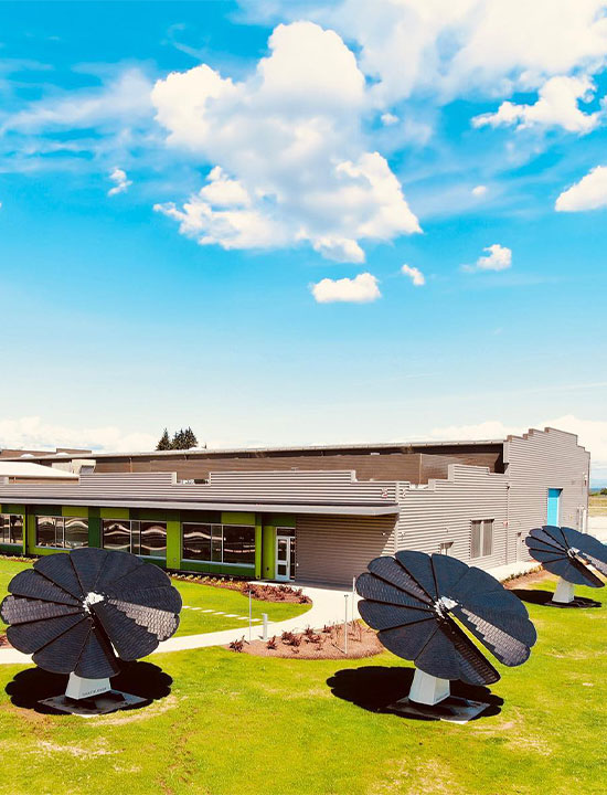 Energy-efficient school campus with SmartFlower solar installations under bright blue sky