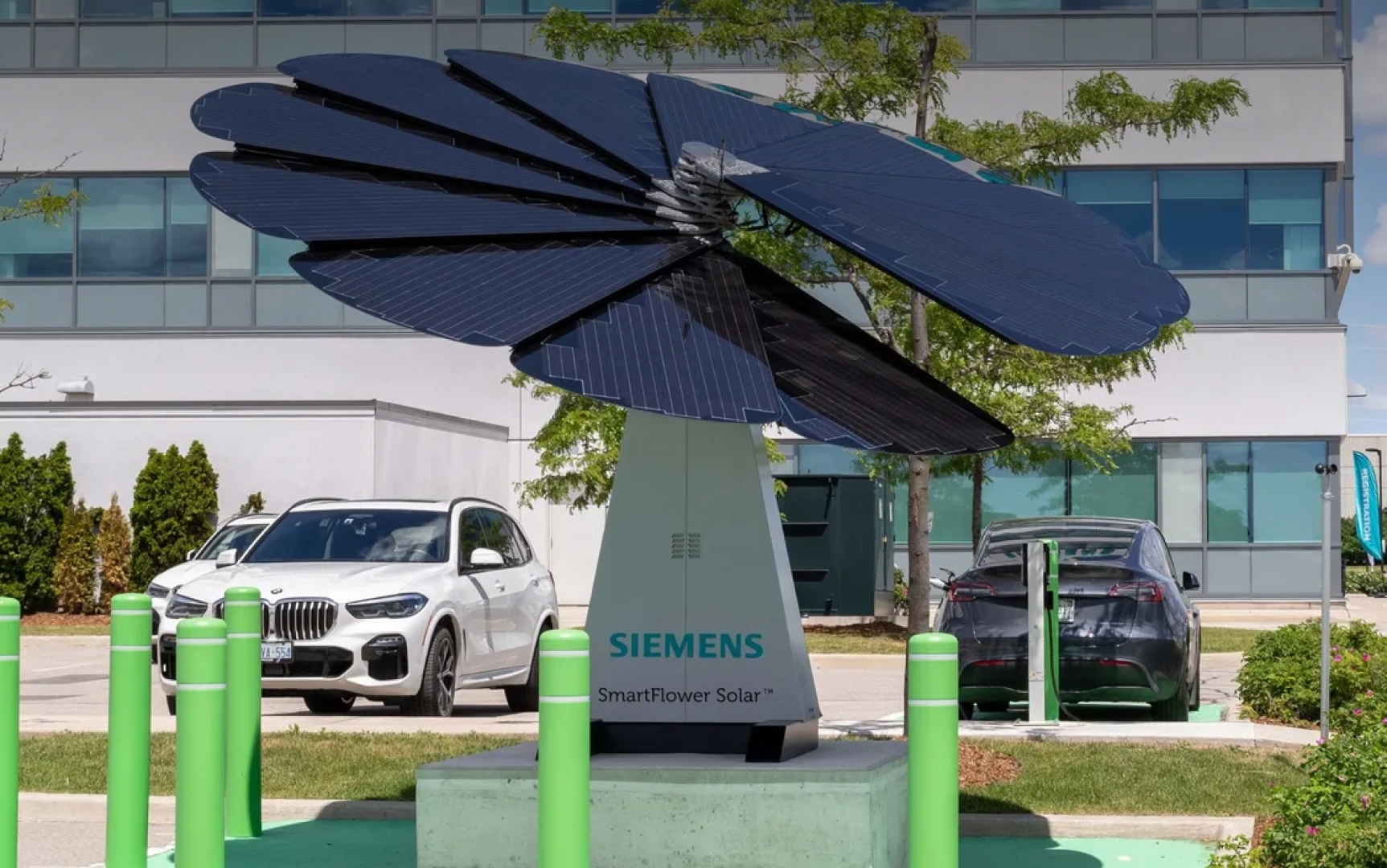 Siemens-branded SmartFlower solar panel powering electric vehicle charging station in corporate parking lot