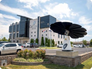 SmartFlower solar panel displayed on raised platform outside OakStar Bank’s modern headquarters building