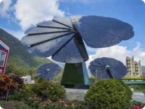 Cluster of SmartFlower solar panels in landscaped garden with mountain backdrop