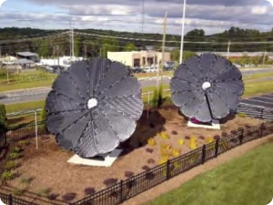 Two SmartFlower solar systems installed side by side near a roadside business area
