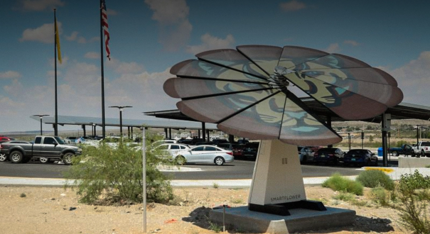 Custom-painted SmartFlower solar panel featuring mascot design installed in desert landscape near parking lot