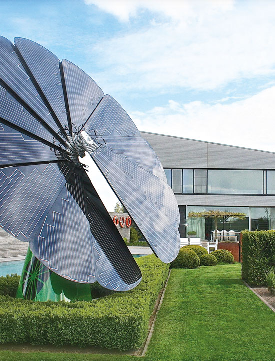 Large flower-shaped solar panel soaking sunlight in luxury home's landscaped front yard