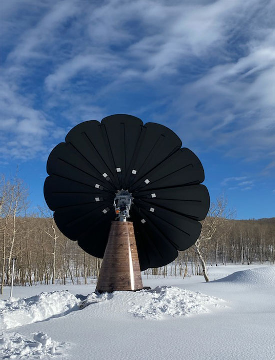 Renewable energy SmartFlower system generating power in serene snowy environment with forest backdrop