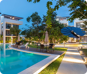 SmartFlower installed on right with a pool and hotel building to the left taken at night